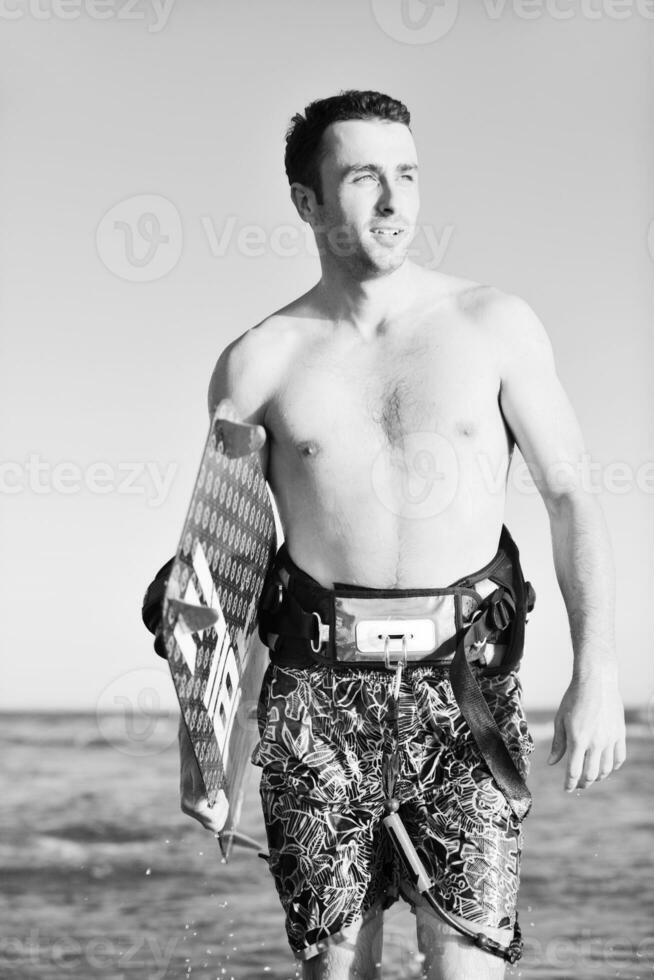 Portrait of a young  kitsurf  man at beach on sunset photo