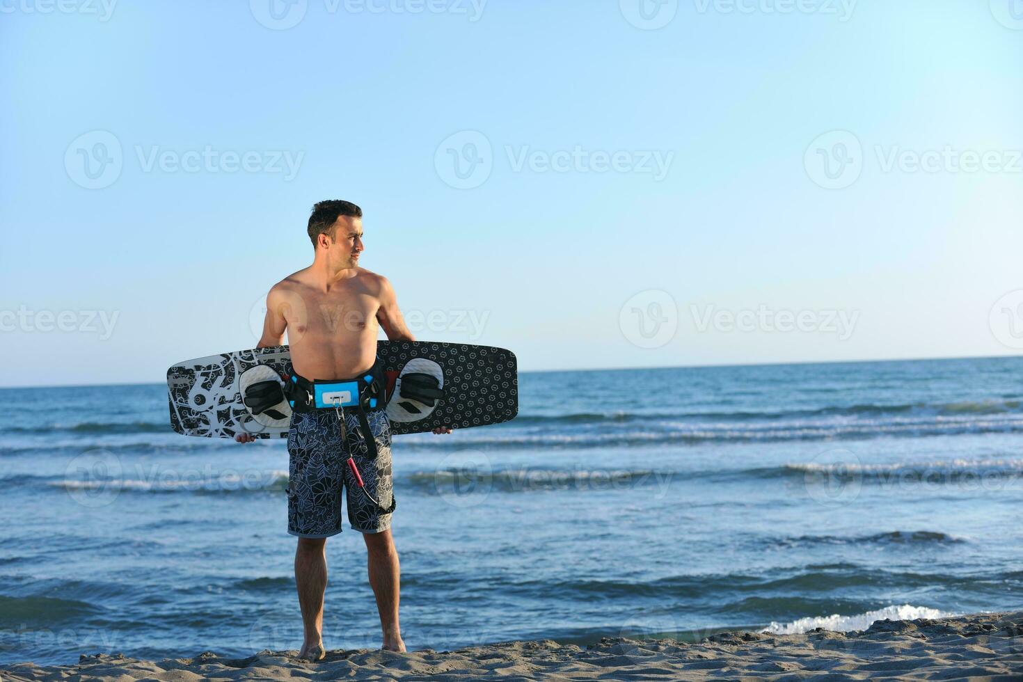 Portrait of a young  kitsurf  man at beach on sunset photo