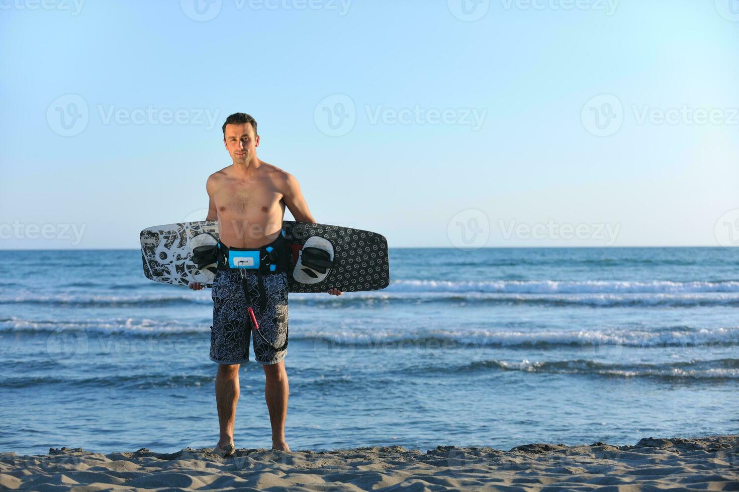 Portrait of a young  kitsurf  man at beach on sunset photo