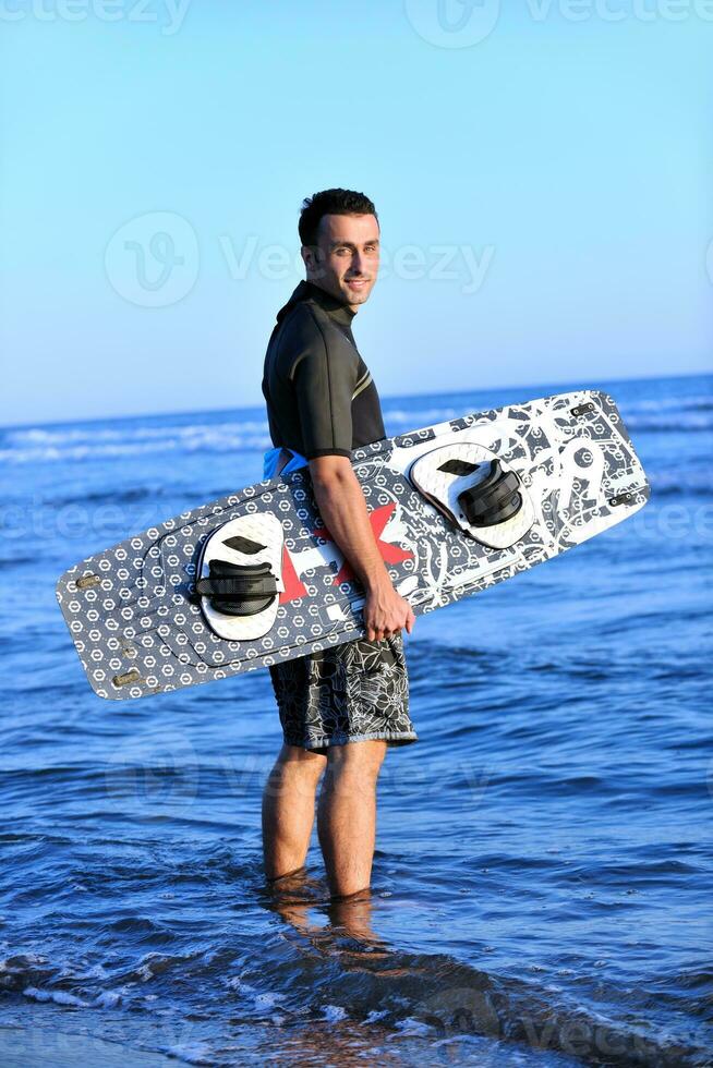 Portrait of a young  kitsurf  man at beach on sunset photo