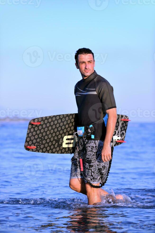 Portrait of a young  kitsurf  man at beach on sunset photo