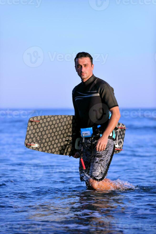 Portrait of a young  kitsurf  man at beach on sunset photo