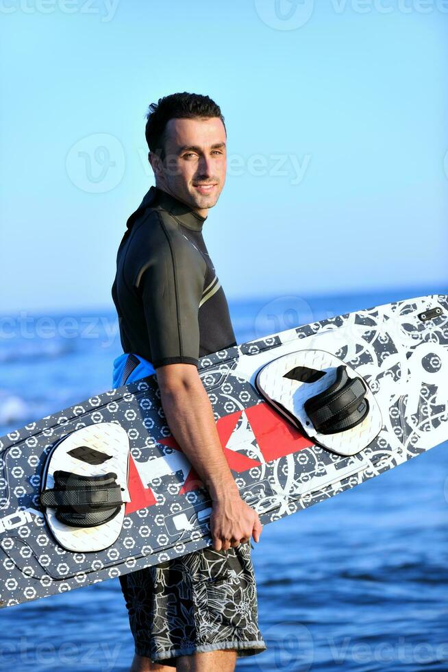 Portrait of a young  kitsurf  man at beach on sunset photo