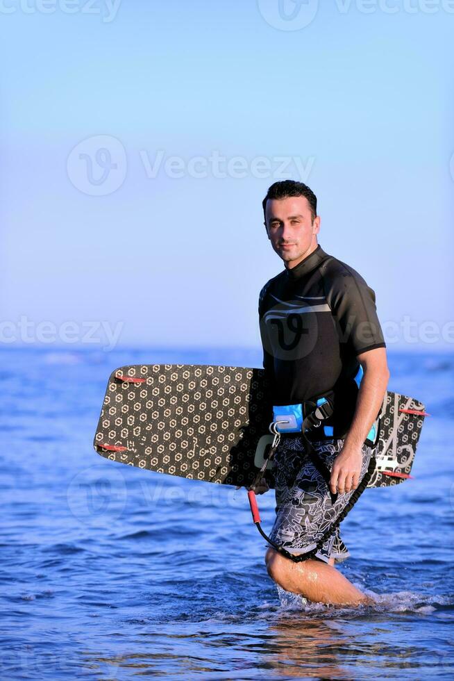 Portrait of a young  kitsurf  man at beach on sunset photo