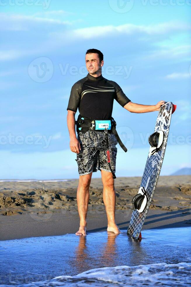 Portrait of a young  kitsurf  man at beach on sunset photo