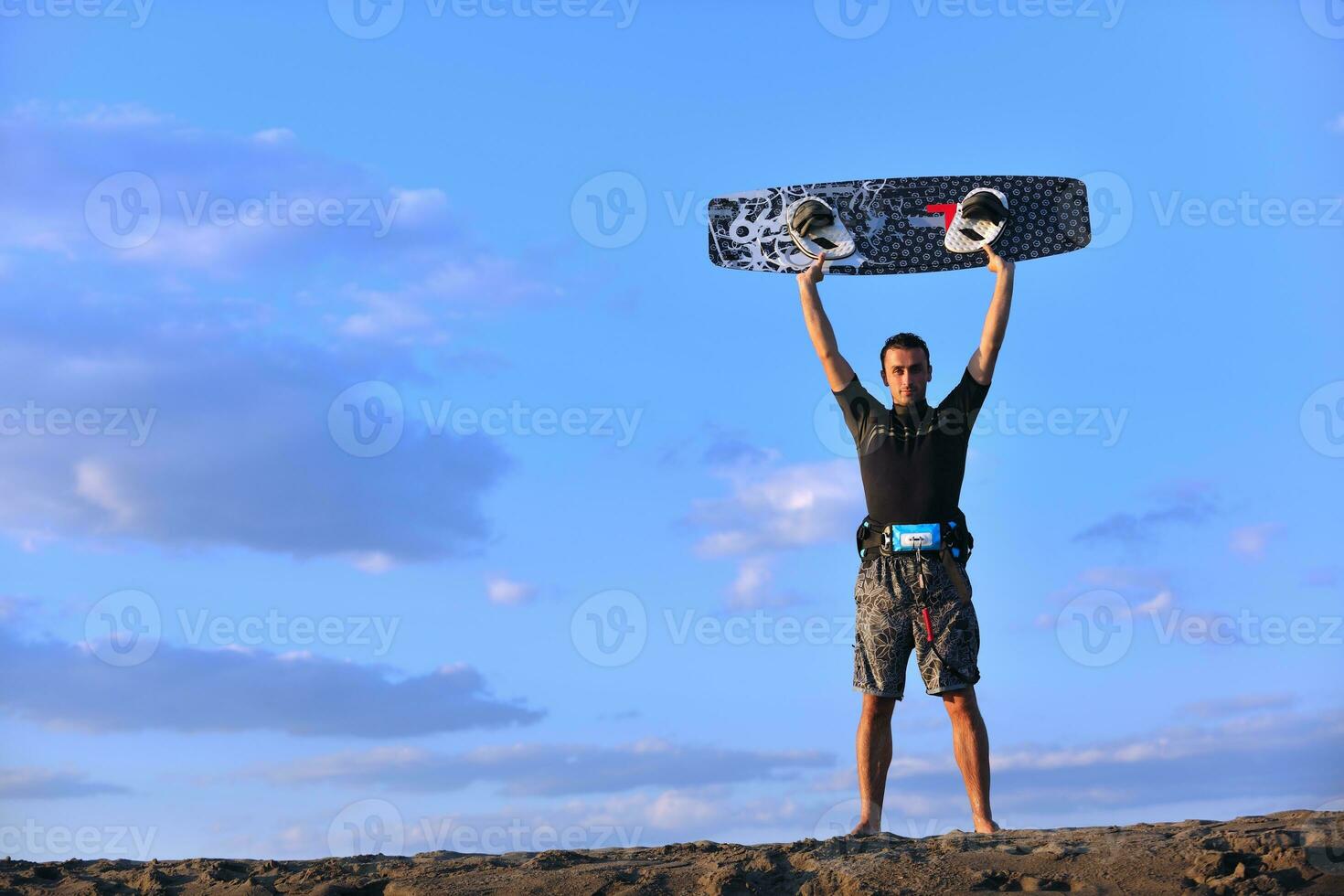 Portrait of a young  kitsurf  man at beach on sunset photo