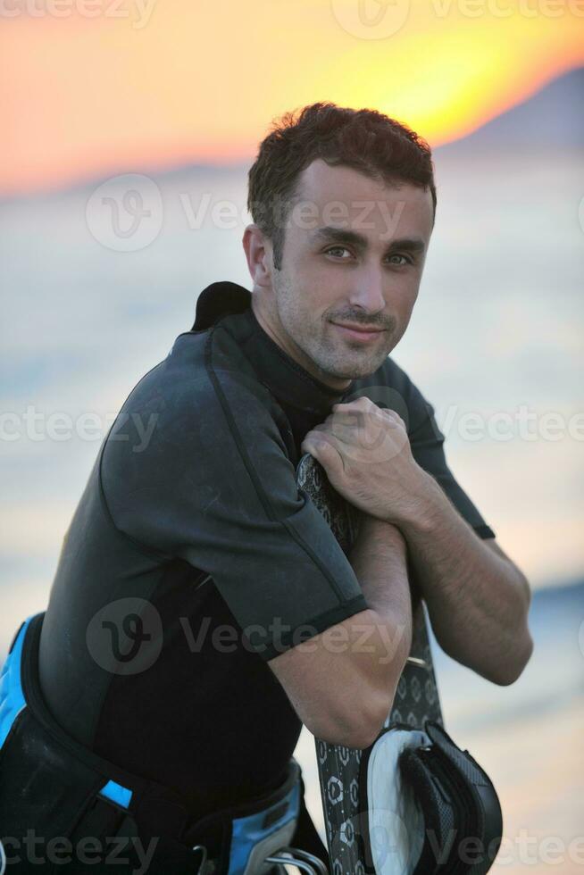 Portrait of a young  kitsurf  man at beach on sunset photo