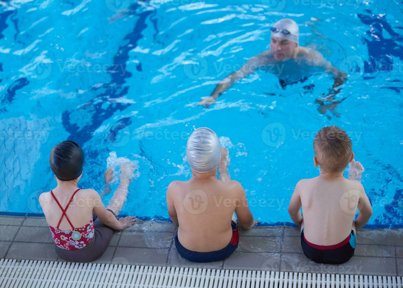 grupo de niños en la clase de la escuela de piscina foto