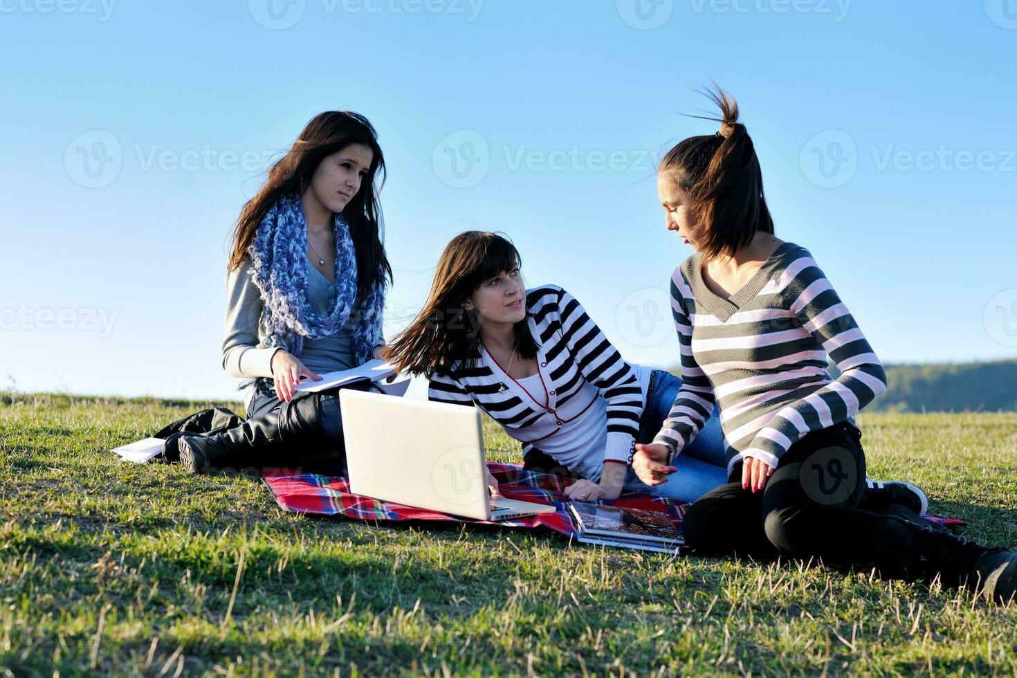 grupo de adolescentes trabajando en una laptop al aire libre foto