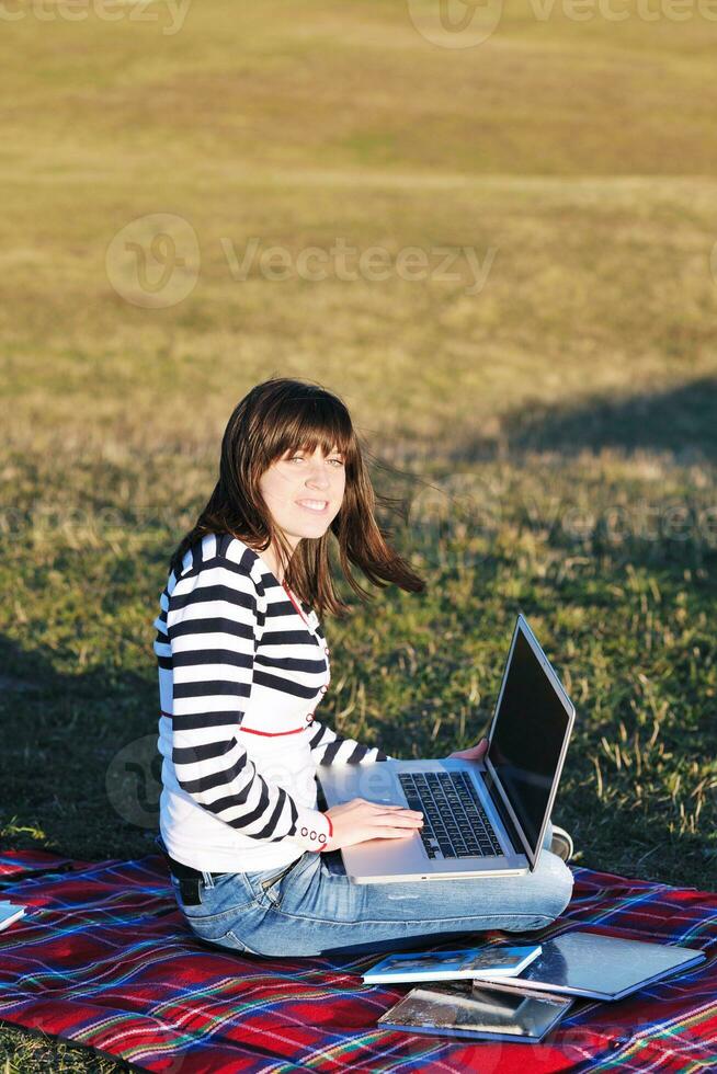 young teen girl work on laptop outdoor photo