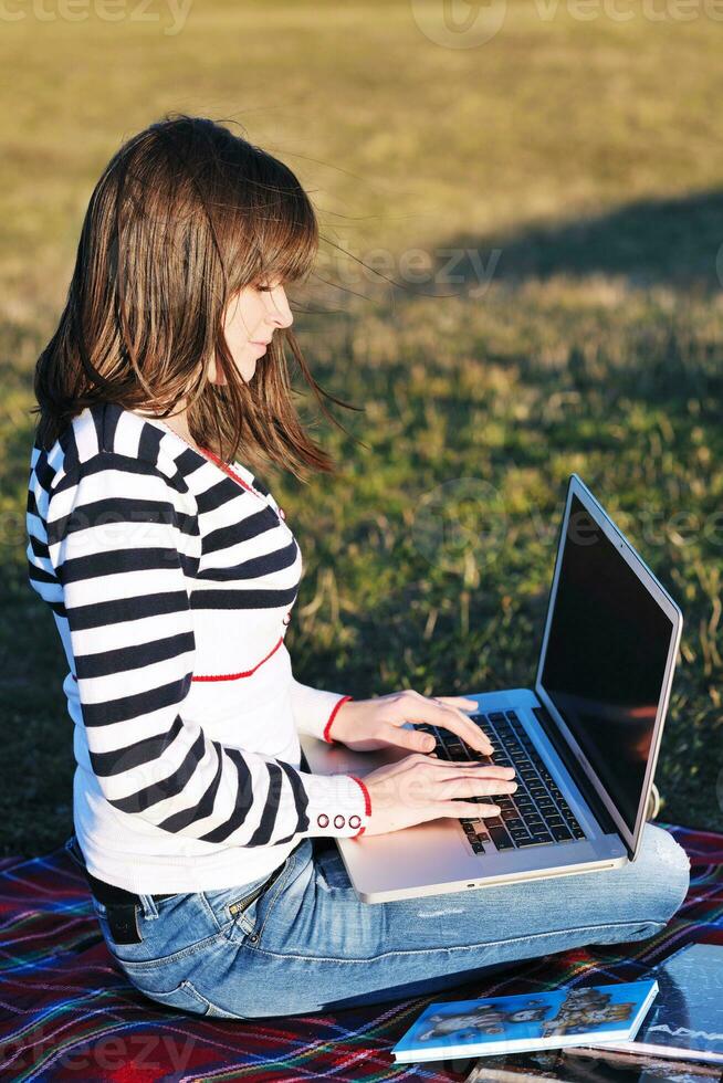 young teen girl work on laptop outdoor photo