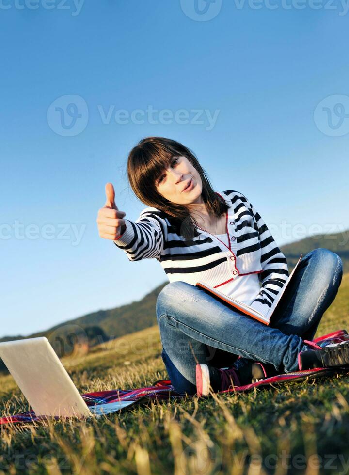 young teen girl work on laptop outdoor photo