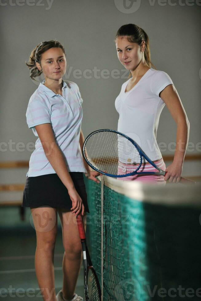 young girls playing tennis game indoor photo