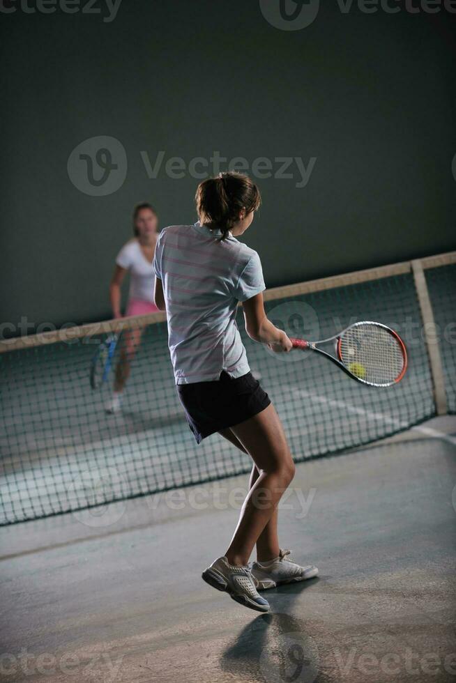 young girls playing tennis game indoor photo