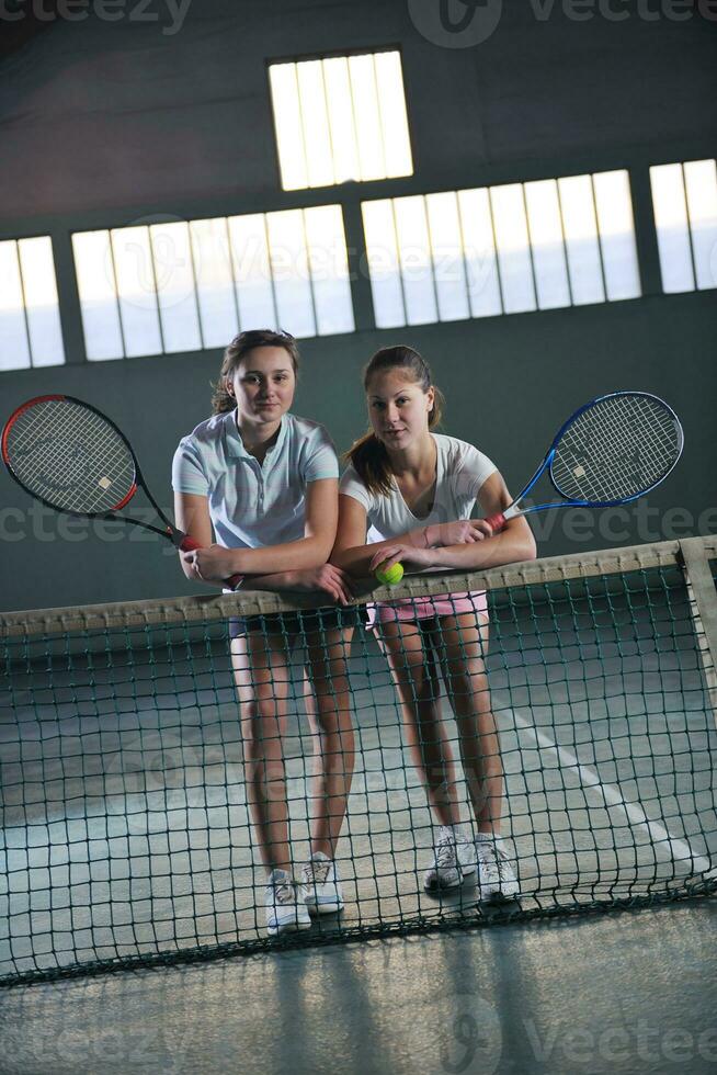 young girls playing tennis game indoor photo