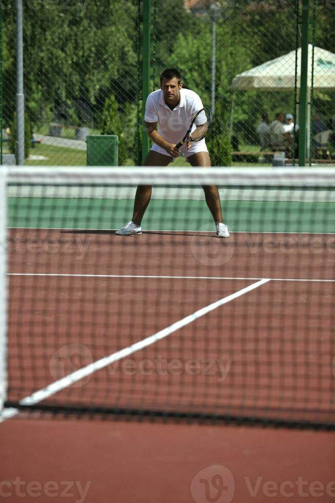 young man play tennis outdoor photo