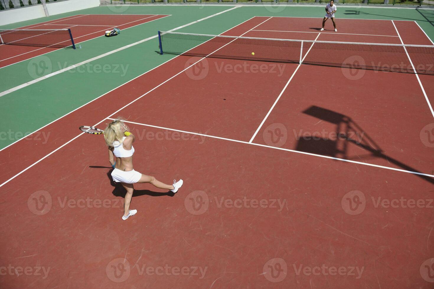 young woman play tennis game outdoor photo