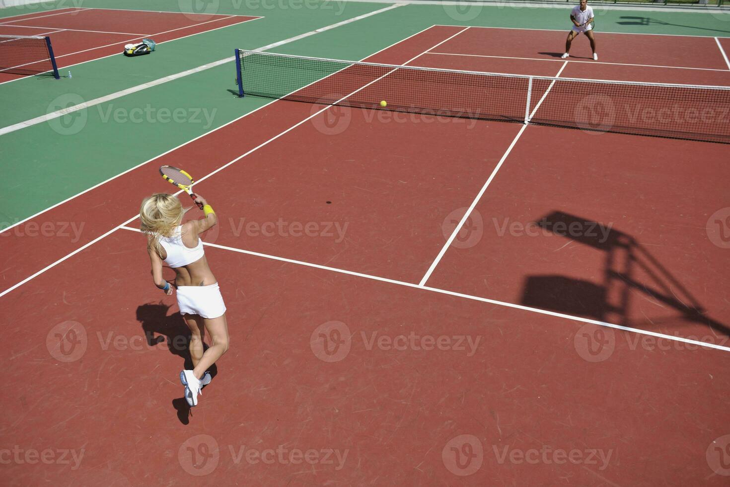 young woman play tennis game outdoor photo