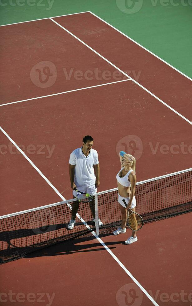 happy young couple play tennis game outdoor photo