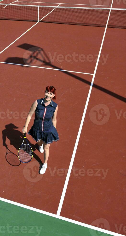 mujer joven jugar juego de tenis al aire libre foto