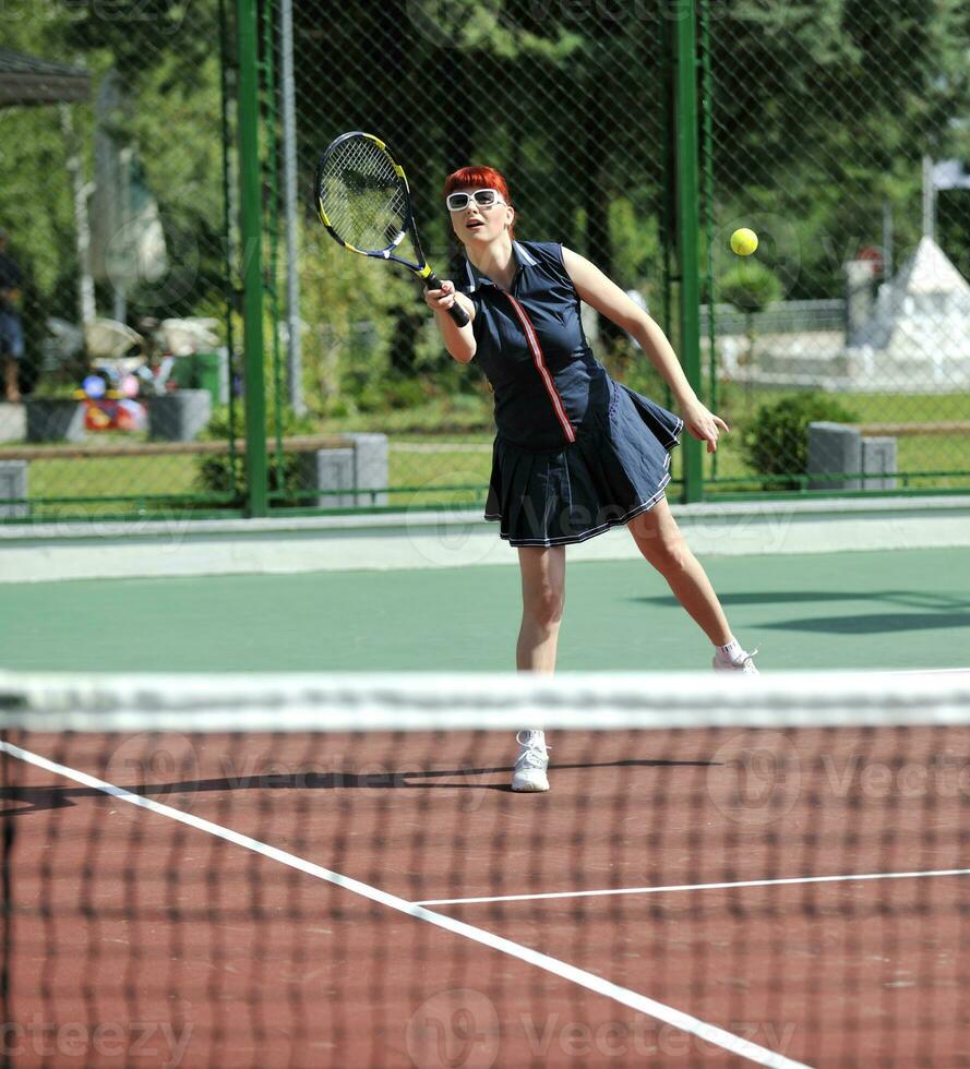 mujer joven jugar juego de tenis al aire libre foto