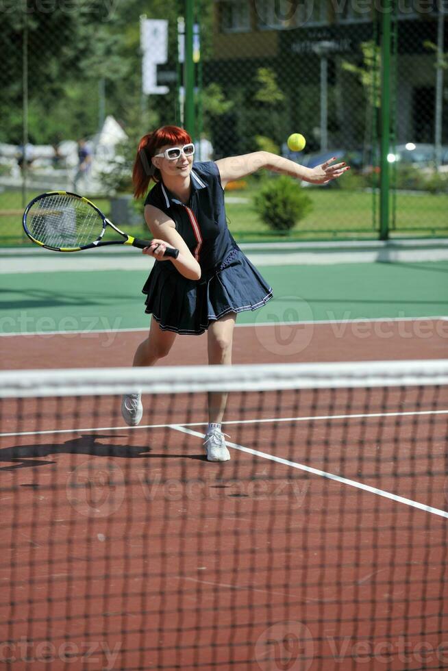 mujer joven jugar juego de tenis al aire libre foto