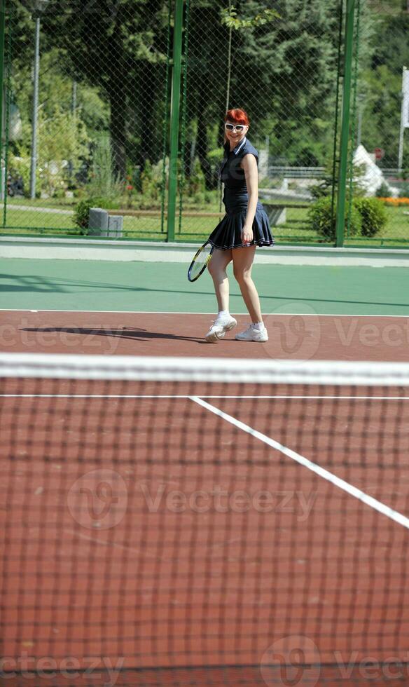 mujer joven jugar juego de tenis al aire libre foto