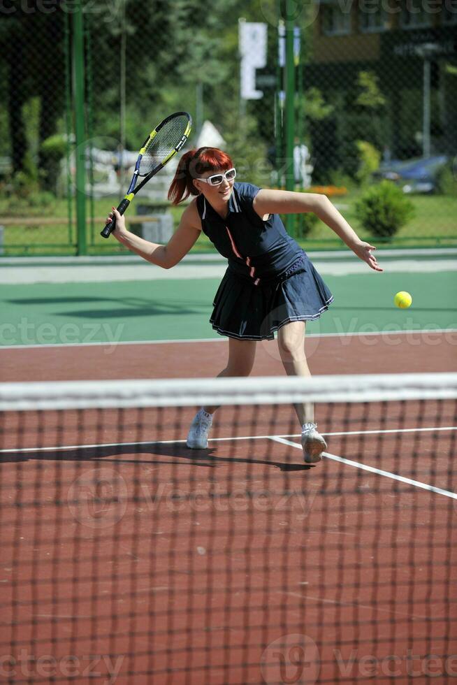 mujer joven jugar juego de tenis al aire libre foto