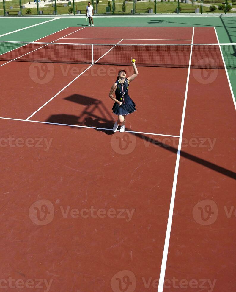 young woman play tennis game outdoor photo