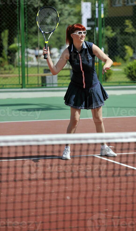 young woman play tennis game outdoor photo