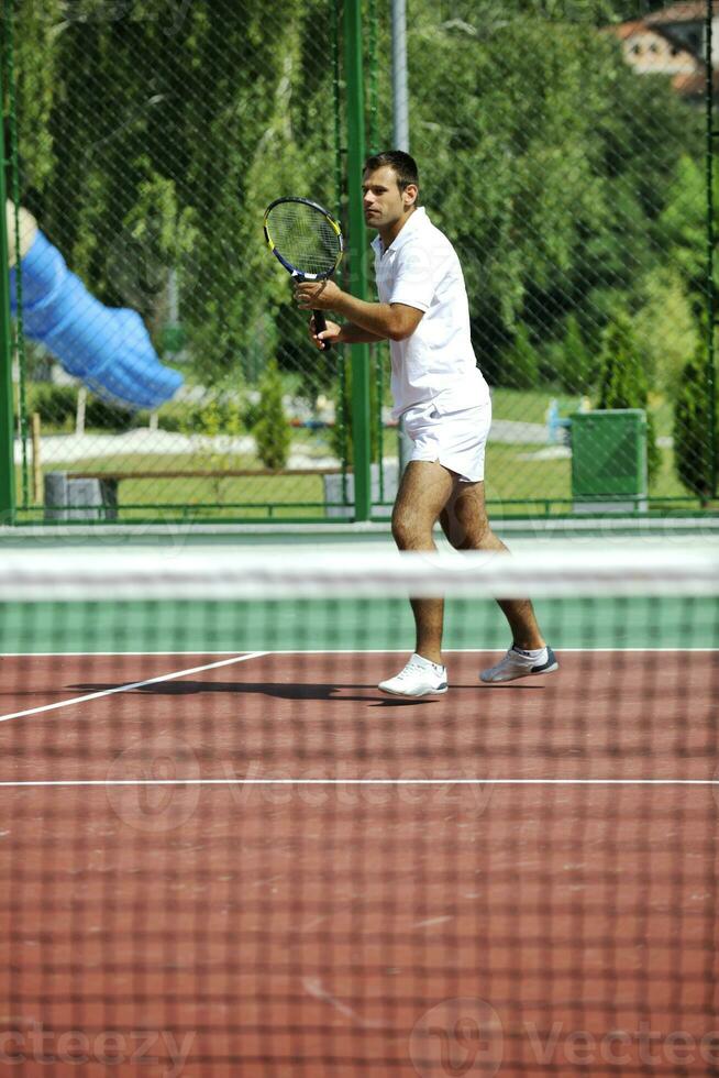 joven jugar al tenis al aire libre foto