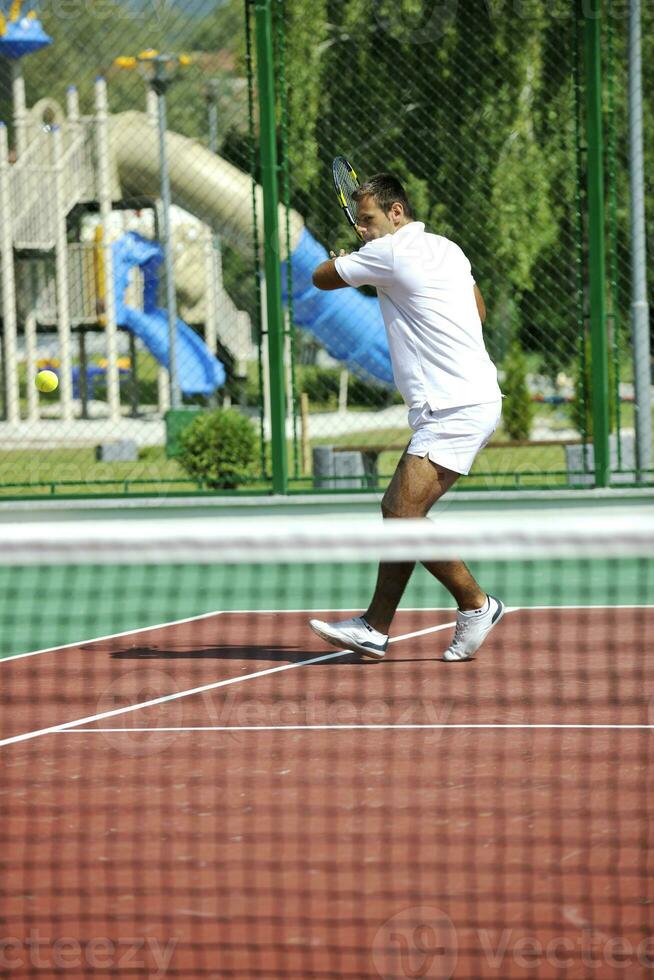 joven jugar al tenis al aire libre foto