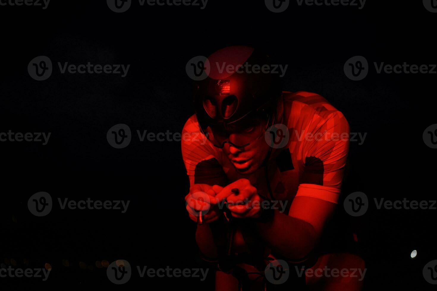 atleta de triatlón montando bicicleta rápido por la noche foto