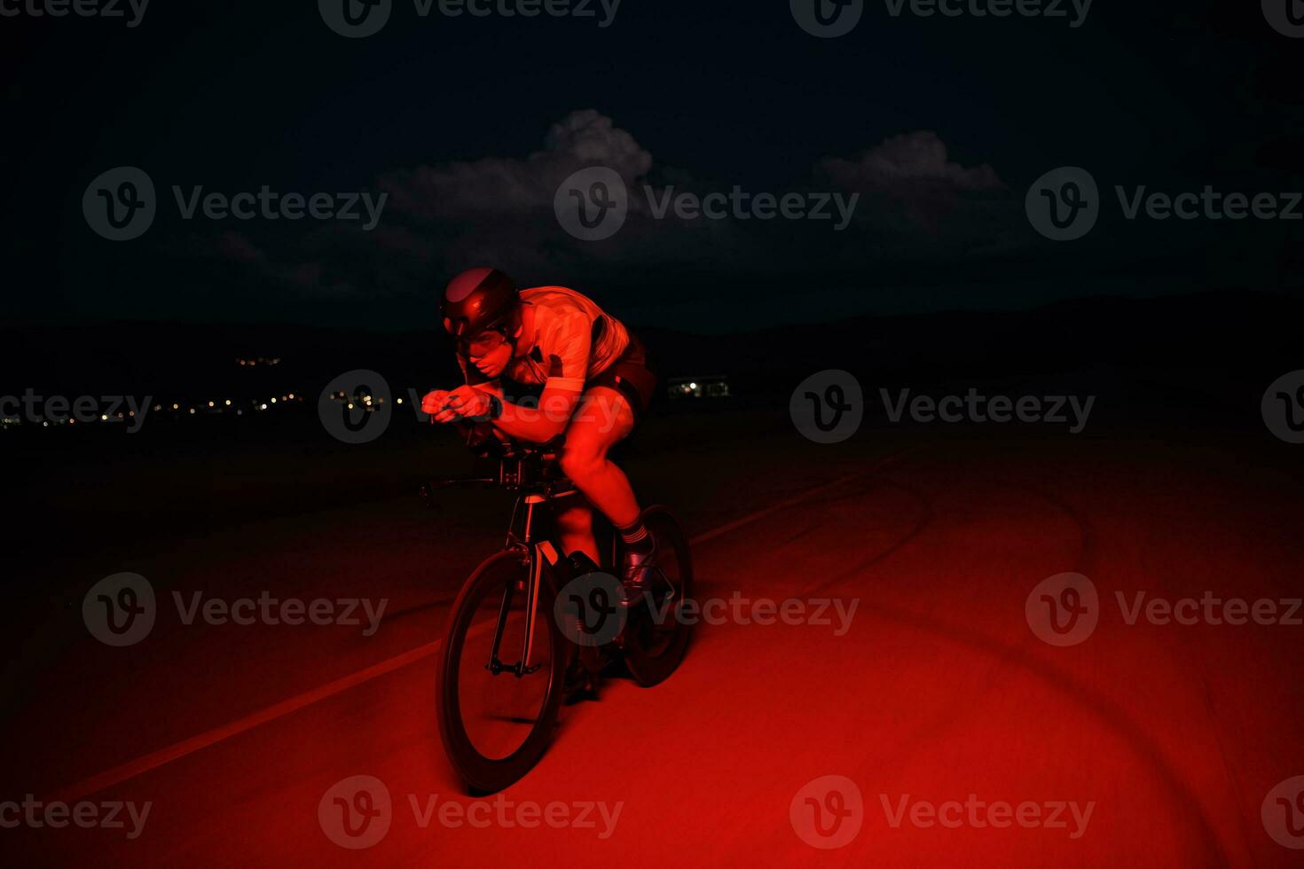 triathlon athlete riding bike fast at night photo