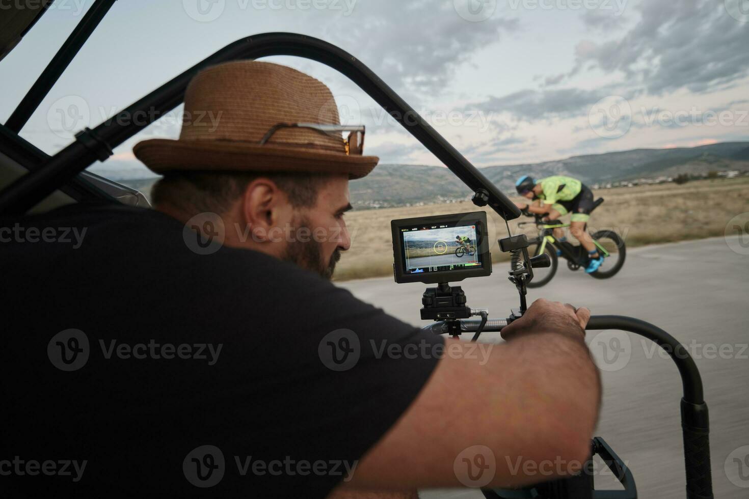 videographer  taking action shot of triathlon athlete while riding bike photo