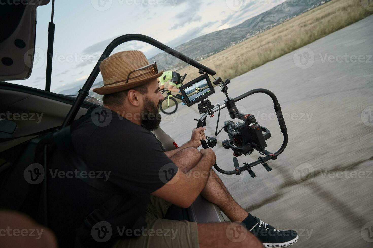 videographer  taking action shot of triathlon athlete while riding bike photo