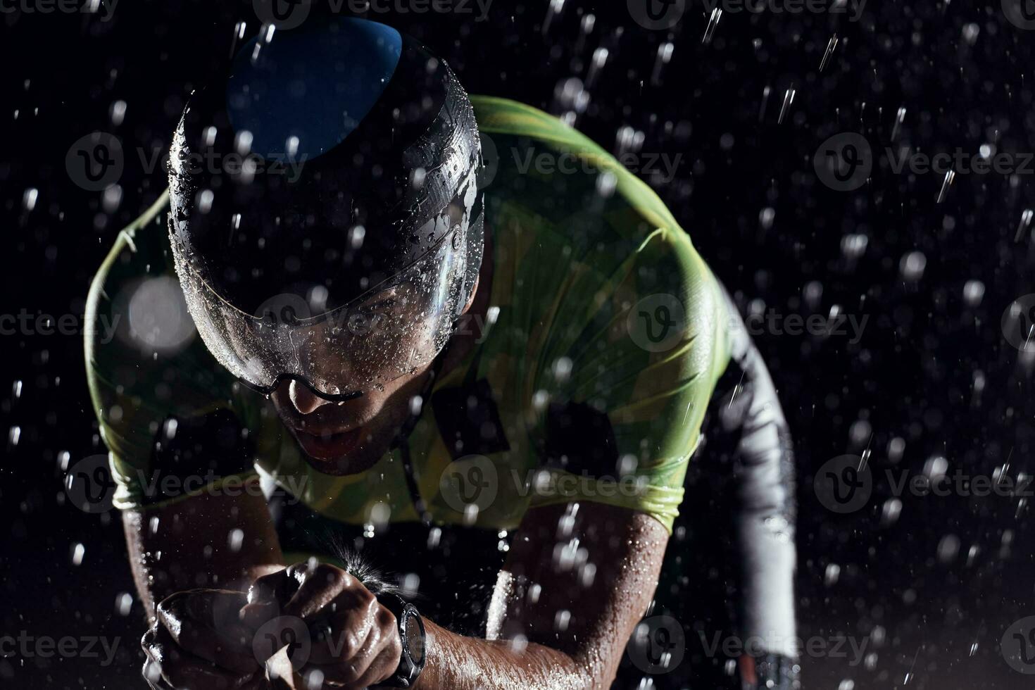 atleta de triatlón montando bicicleta rápido en una noche lluviosa foto