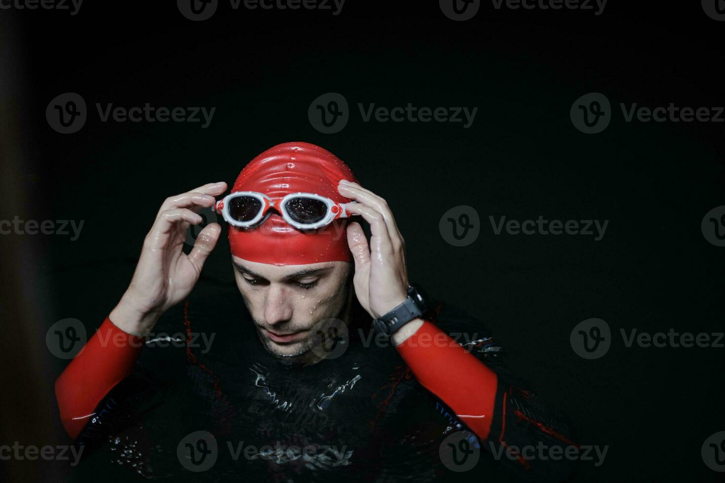 authentic triathlete swimmer having a break during hard training on night photo