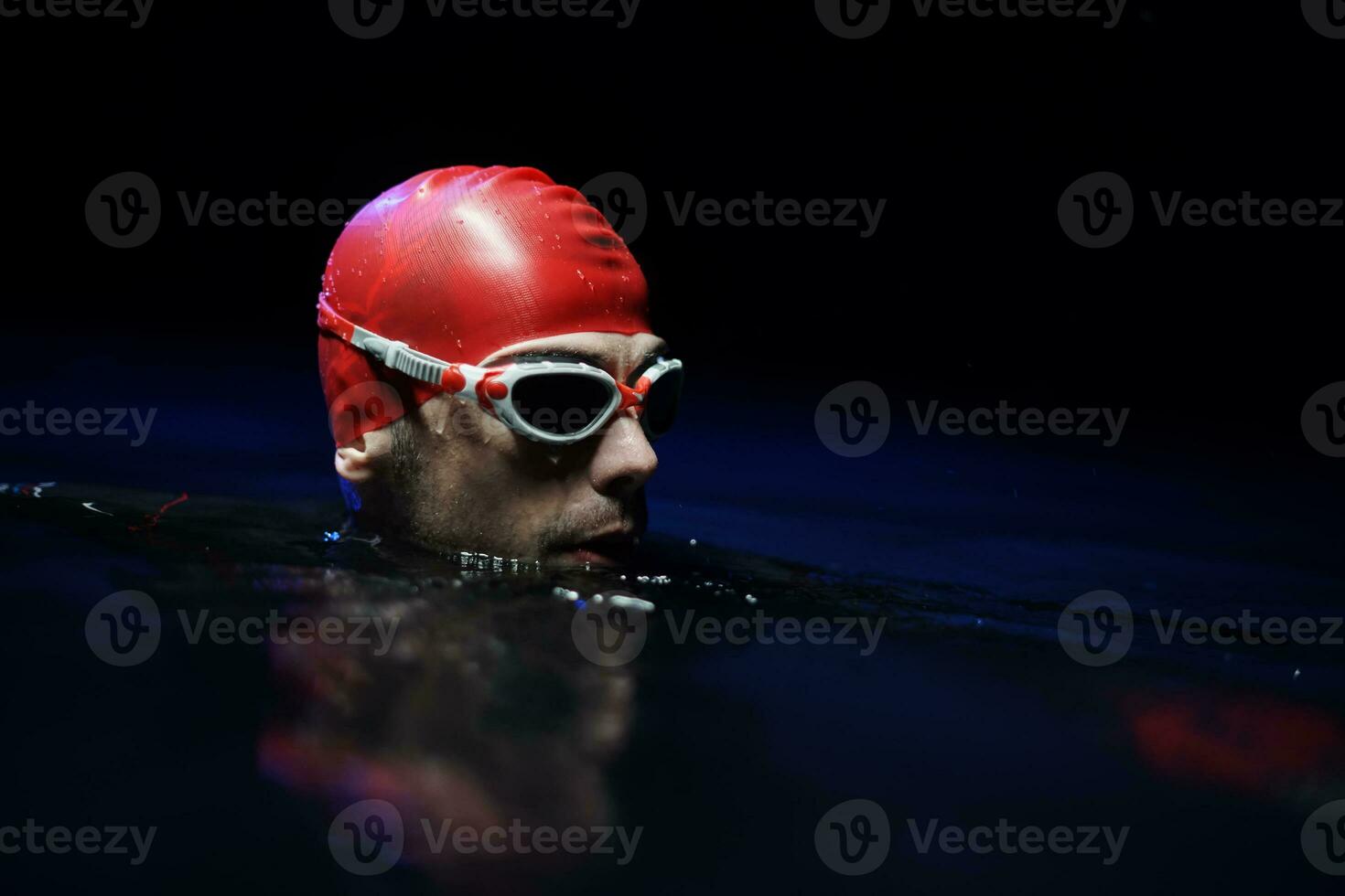 authentic triathlete swimmer having a break during hard training on night photo