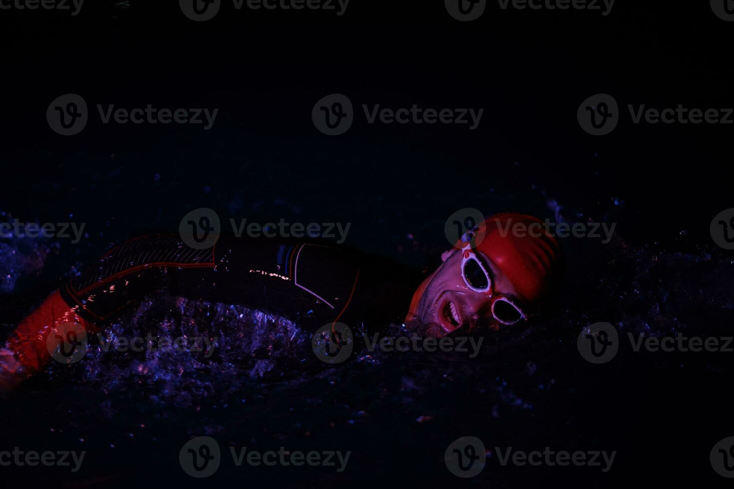 real triathlon athlete swimming in dark night photo