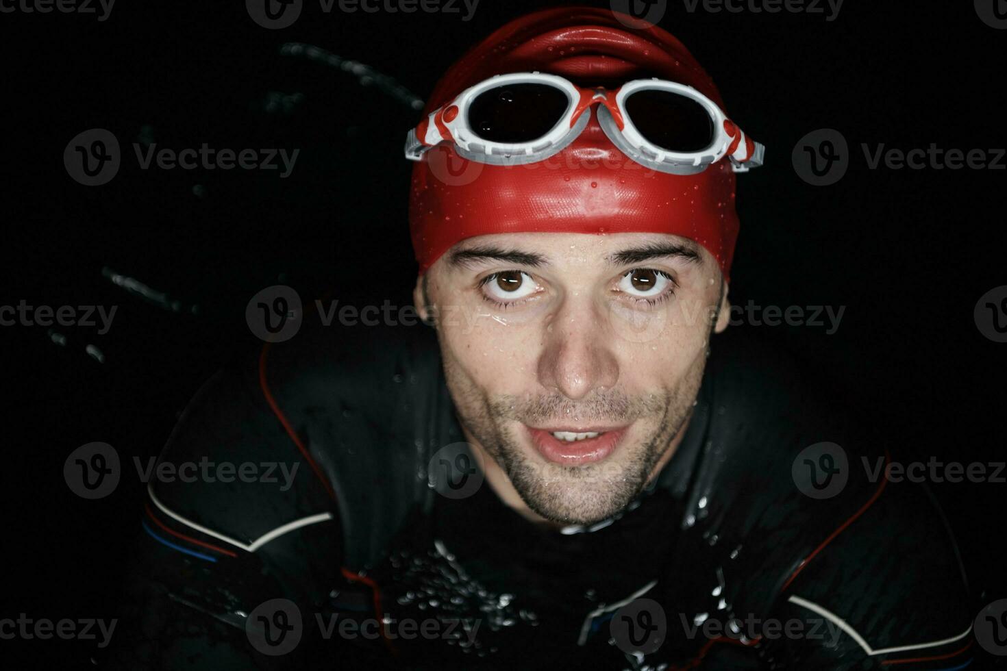authentic triathlete swimmer having a break during hard training on night photo