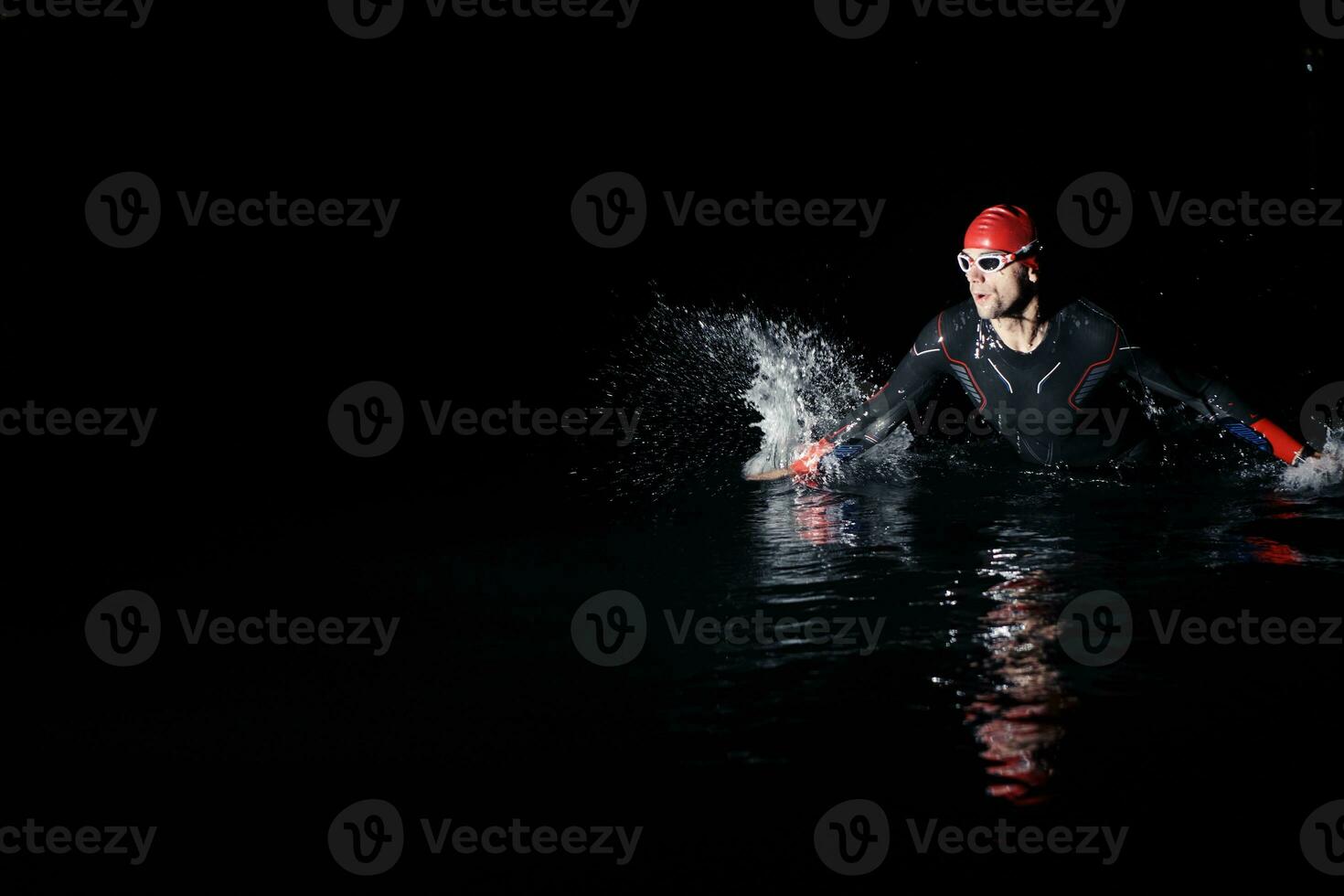 triatlón atleta refinamiento nadando formación a oscuro noche foto