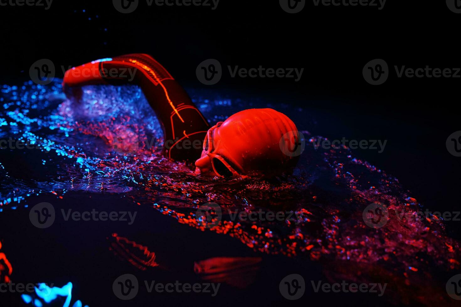 real triathlon athlete swimming in dark night photo