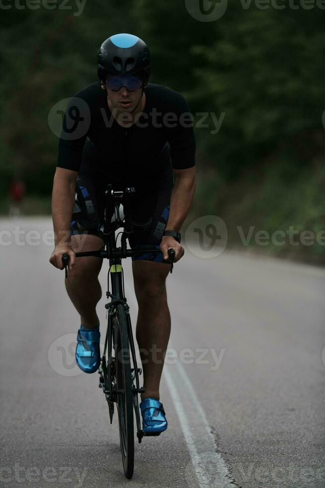 triathlon athlete riding a bike wearing black photo