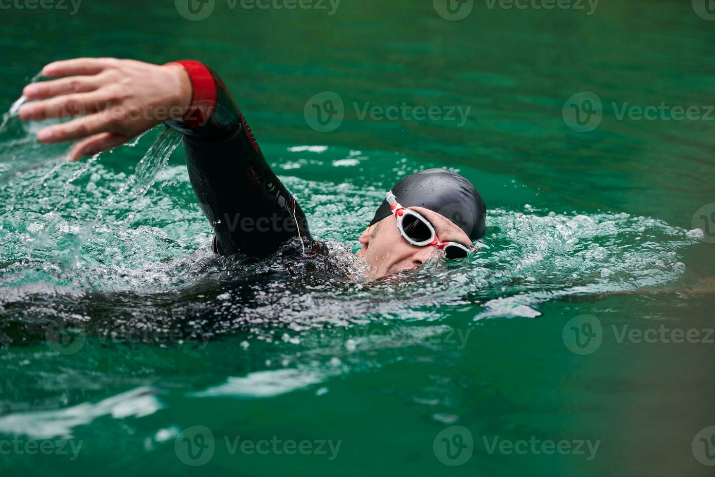 triathlon athlete swimming on lake wearing wetsuit photo