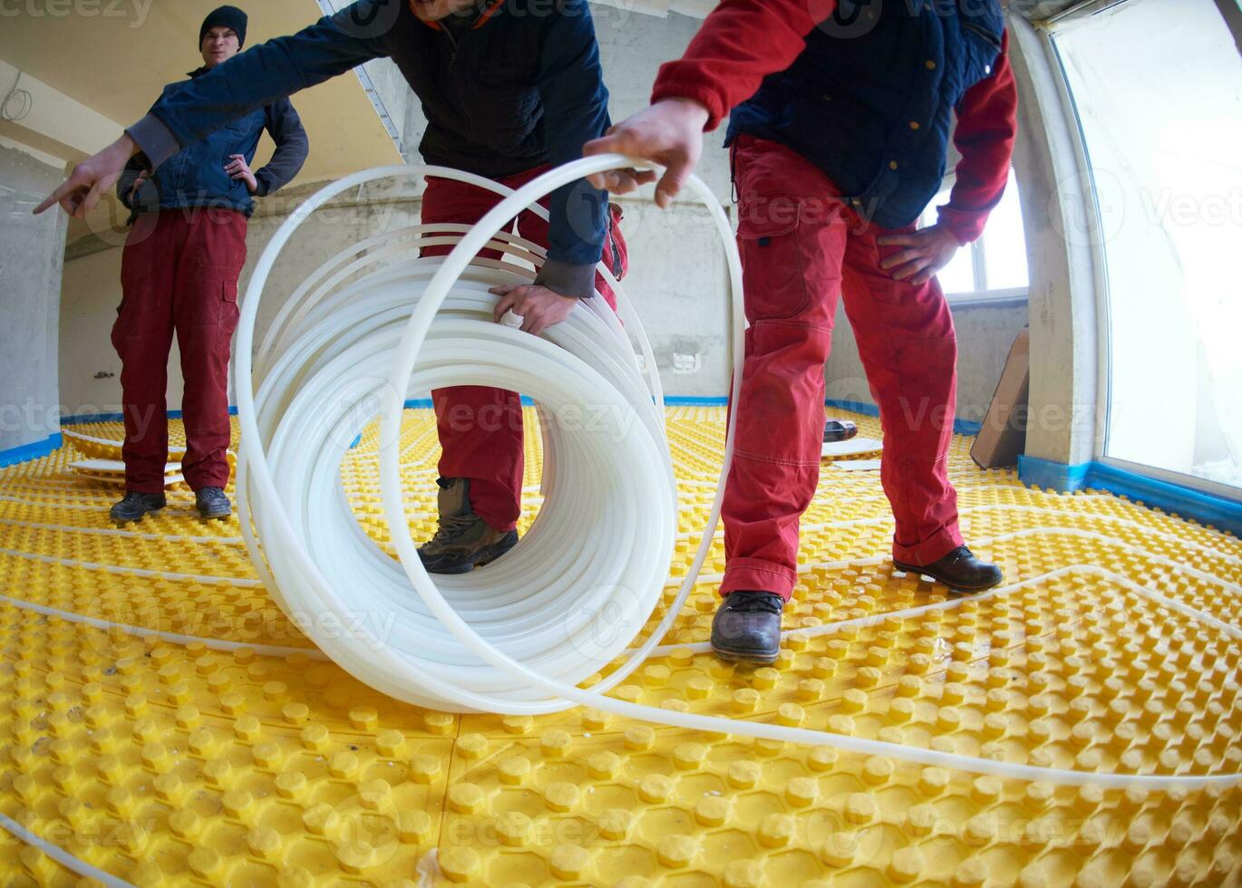 workers installing underfloor heating system photo