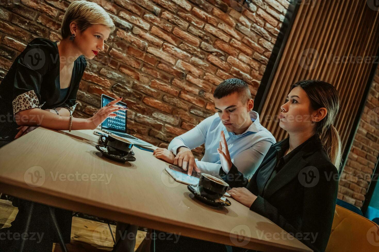 Happy businesspeople smiling cheerfully during a meeting in a coffee shop. Group of successful business professionals working as a team in a multicultural workplace. photo