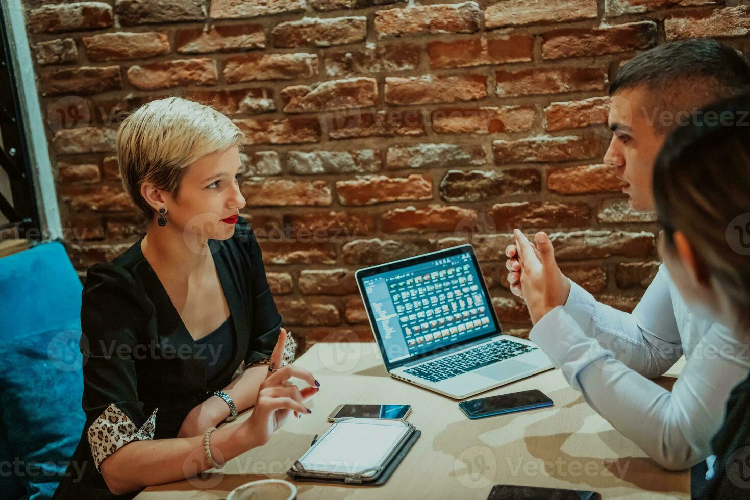 Happy businesspeople smiling cheerfully during a meeting in a coffee shop. Group of successful business professionals working as a team in a multicultural workplace. photo