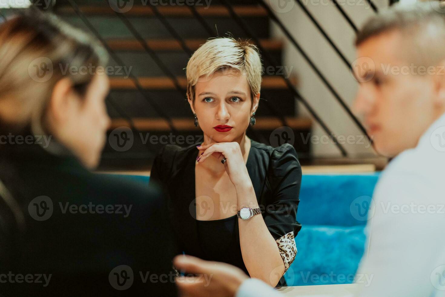 Happy businesspeople smiling cheerfully during a meeting in a coffee shop. Group of successful business professionals working as a team in a multicultural workplace. photo