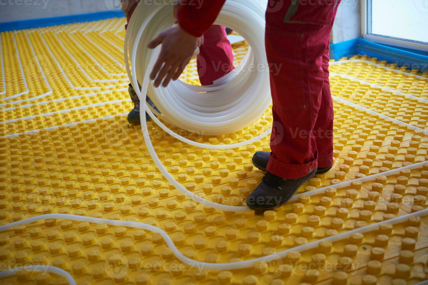 workers installing underfloor heating system photo